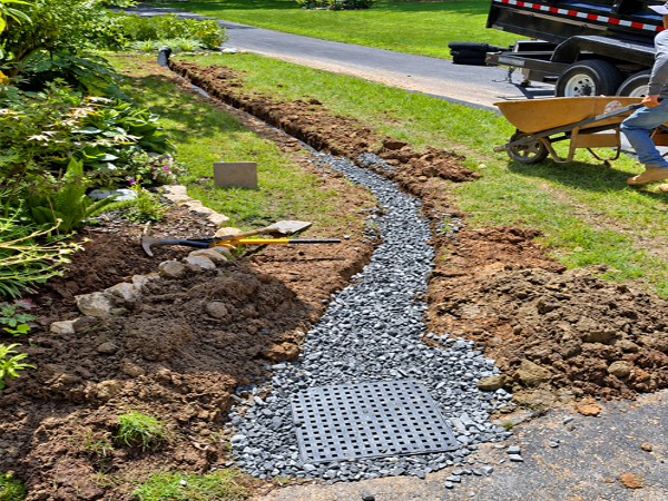 Decorative stone French drain beside a lawn